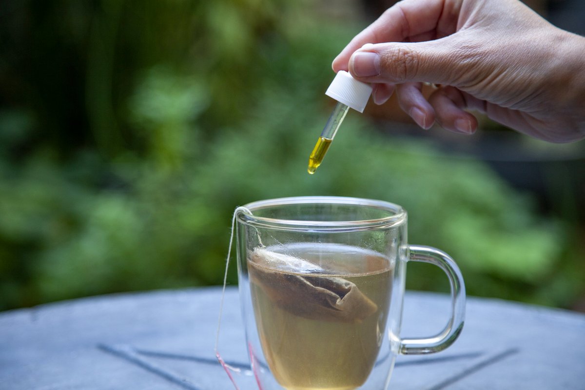 Huile de CBD avec pipette dans verre de thé